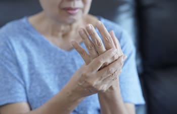 A woman holding her aching wrist